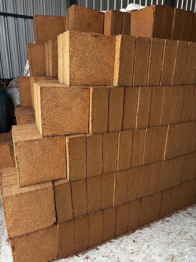 Stacks of 5 kg coco peat blocks in a warehouse